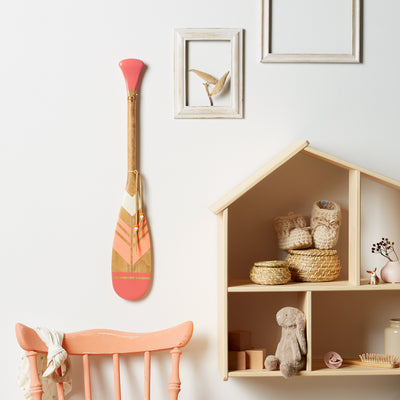 Pagaie décorative de petite taille (24 pouces). Pagaie en bois de trois couleurs fixée à un mur blanc. Munie d'un lacet en cuir décoratif  – Onquata à Wendake